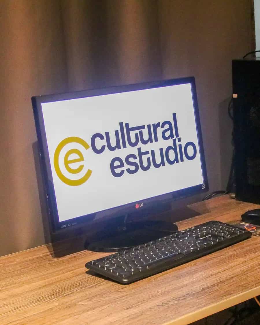 Mesa do Cultural Estúdio em Votuporanga, com monitor exibindo o logo do estúdio